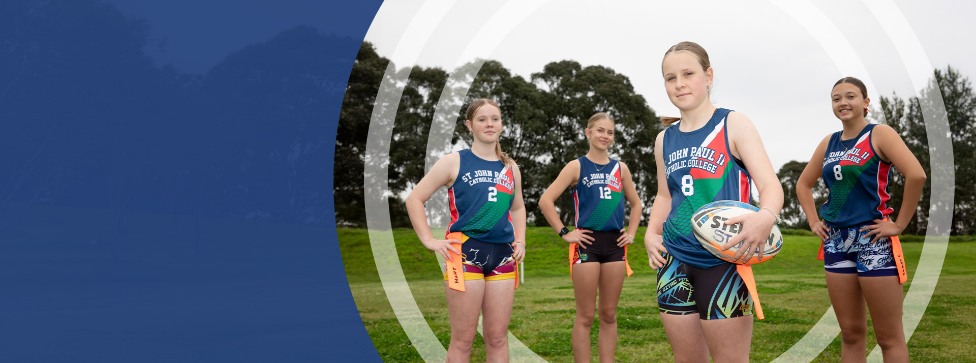 The girls football team standing on the school oval at St John Paul II Catholic College Schofields