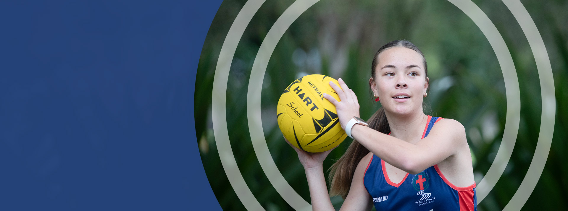 Student throwing a netball on the school oval at St John Paul II Catholic College Schofields
