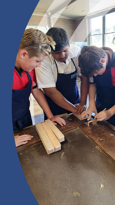 Students working together in the wood work room at St John Paul II Catholic College Schofields