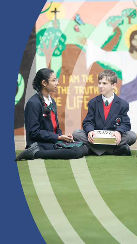 Students sitting together in front of a mural at St John Paul II Catholic College Schofields