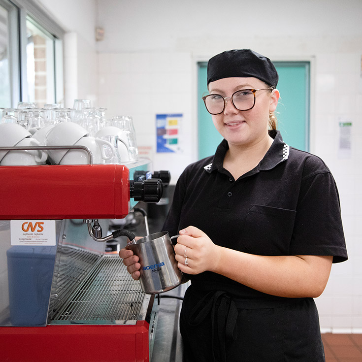 Student brewing coffee in the hospitality area at St John Paul II Catholic College Schofields and Nirimba