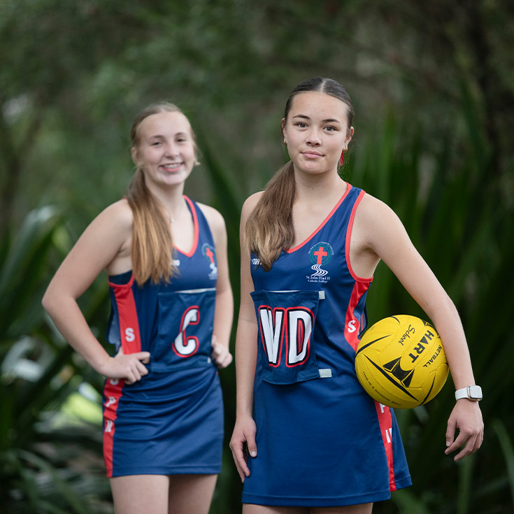Students from the netball team on the school oval at St John Paul II Catholic College Schofields