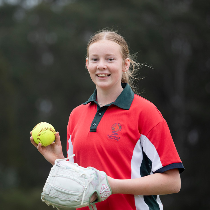 Student playing cricket on the school oval at St John Paul II Catholic College Schofields